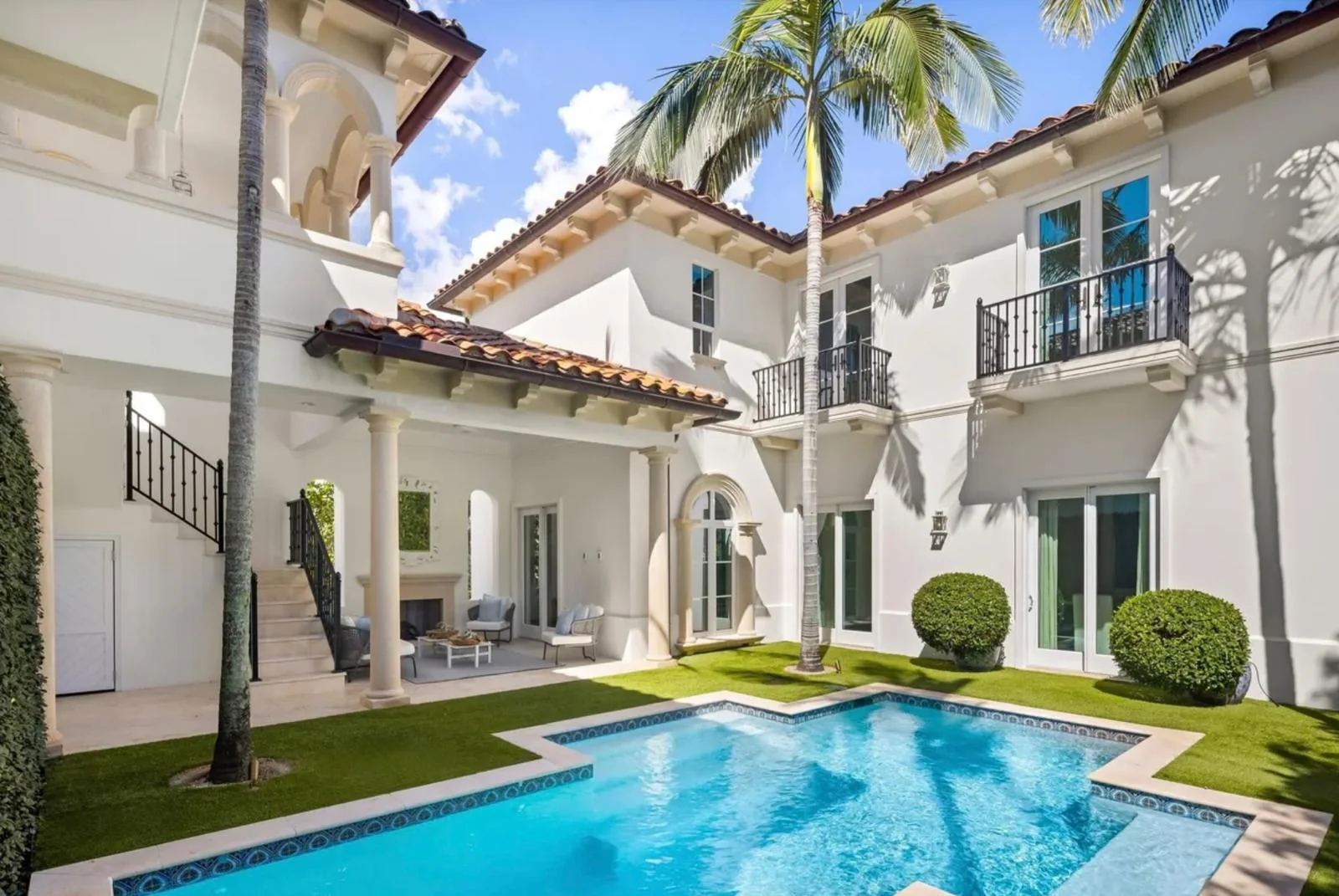 Cream exterior walls and arched balconies around a courtyard pool