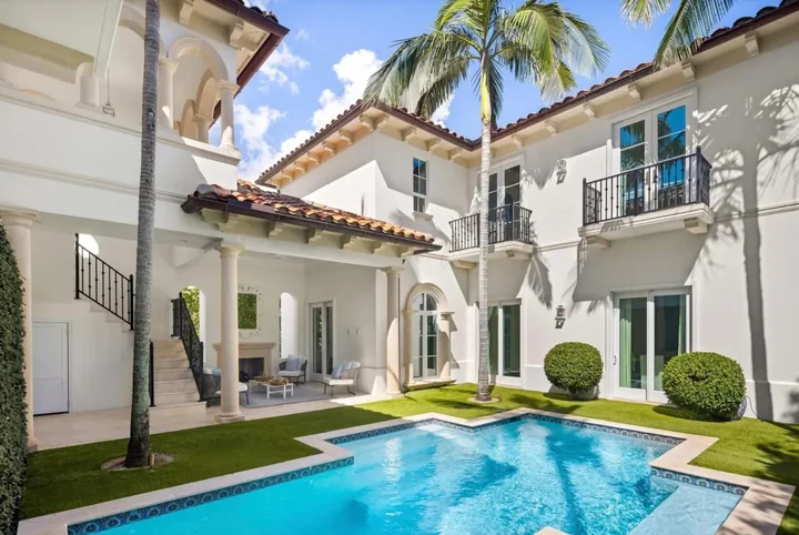 Cream exterior walls and arched balconies around a courtyard pool