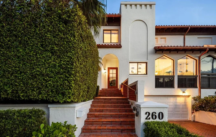 Cream house exterior with warm wood details and a terracotta entrance stair