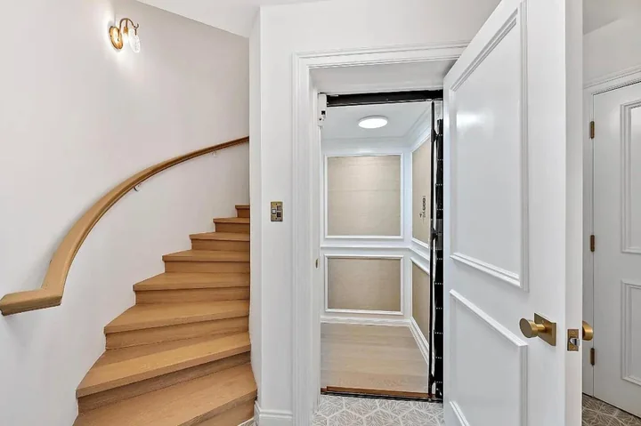 White paneled doors and wall trim beside a curved wood stair